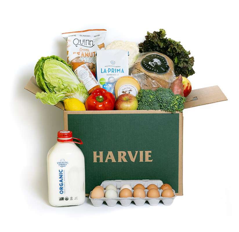 A Harvie grocery box with eggs, milk, produce, bread, and pantry items